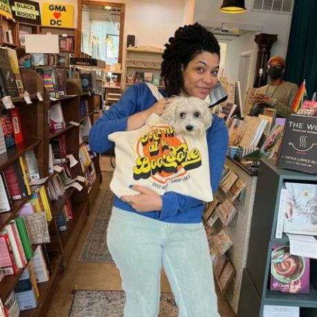 Loyalty Bookstore founder, Hannah Oliver Depp, holds a bookstore tote bag with a dog inside.