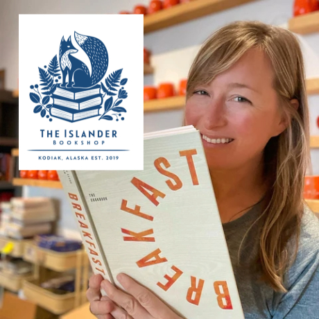 Founder and Co-owner of The Islander Bookshop, Melissa Haffeman, holds a book and smiles.