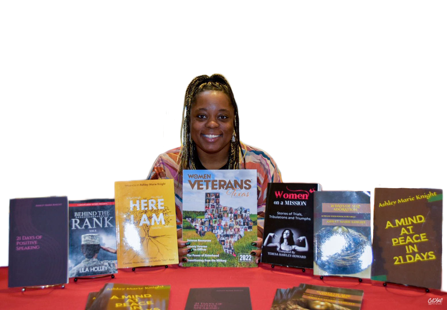Words Unite founder, Ashley Booker-Knight sits behind a row of books.