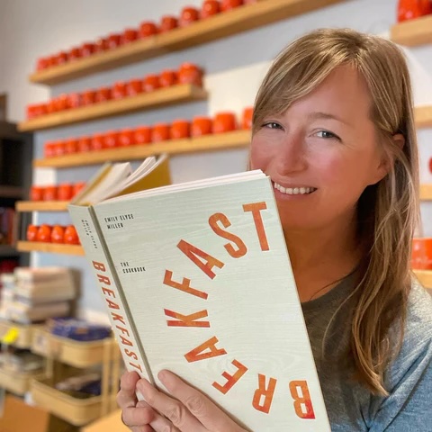 Islander Bookshop founder and co-owner, Melissa Haffeman, holds a book and smiles.